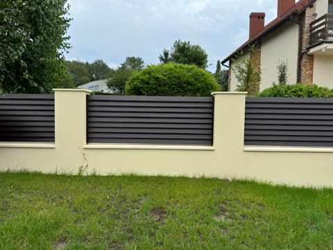 Nowoczesne ogrodzenie panelowe z antracytowych profili i jasnych murowanych słupków